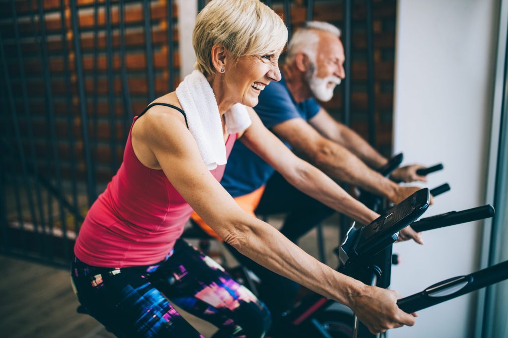 2 Senioren sind glücklich auf einem Heimtrainer